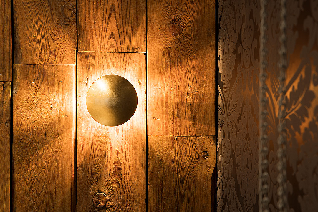 Goldlampe auf Holzvertäfelung